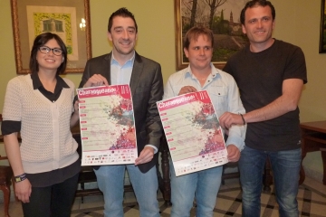 Los organizadores posan con el cartel.